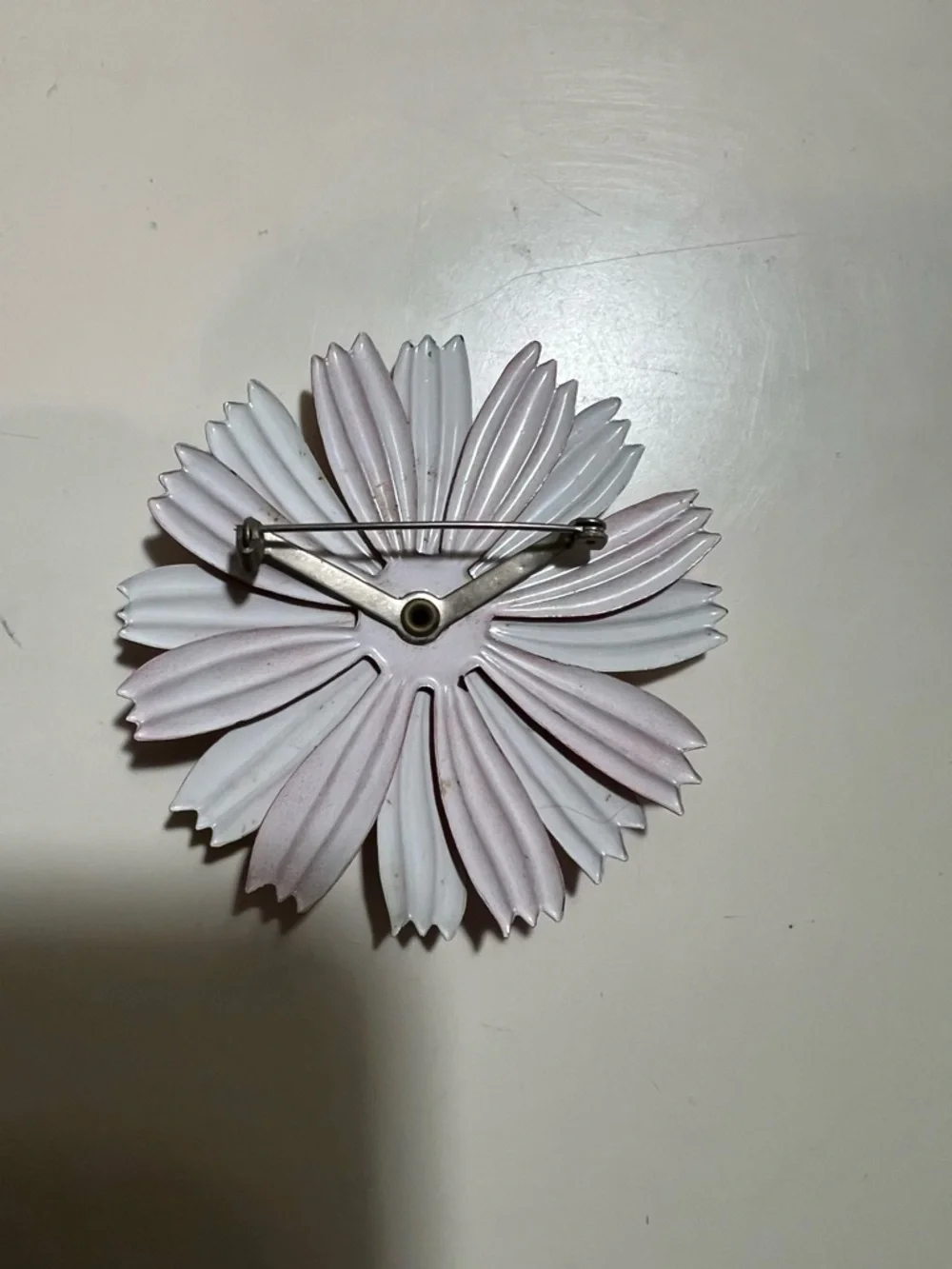 1960s enamel brooch with red and white petals and blue dome center.